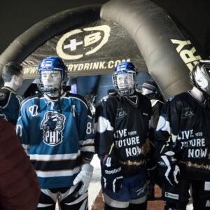 A group of ice cross hockey players poses in front of a tent, showcasing their team spirit and athleticism.