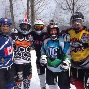 A group of individuals standing together in the snow, showcasing the excitement of an ice cross event.