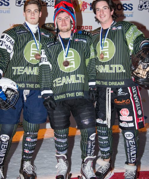 Three men in green and black uniforms prepare for an ice cross competition, showcasing teamwork and athleticism.